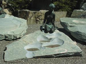 Brunnen mit Bronzegu-Figur Stein Naturstein Gartenbrunnen Steinmetz sterreich Vorarlberg